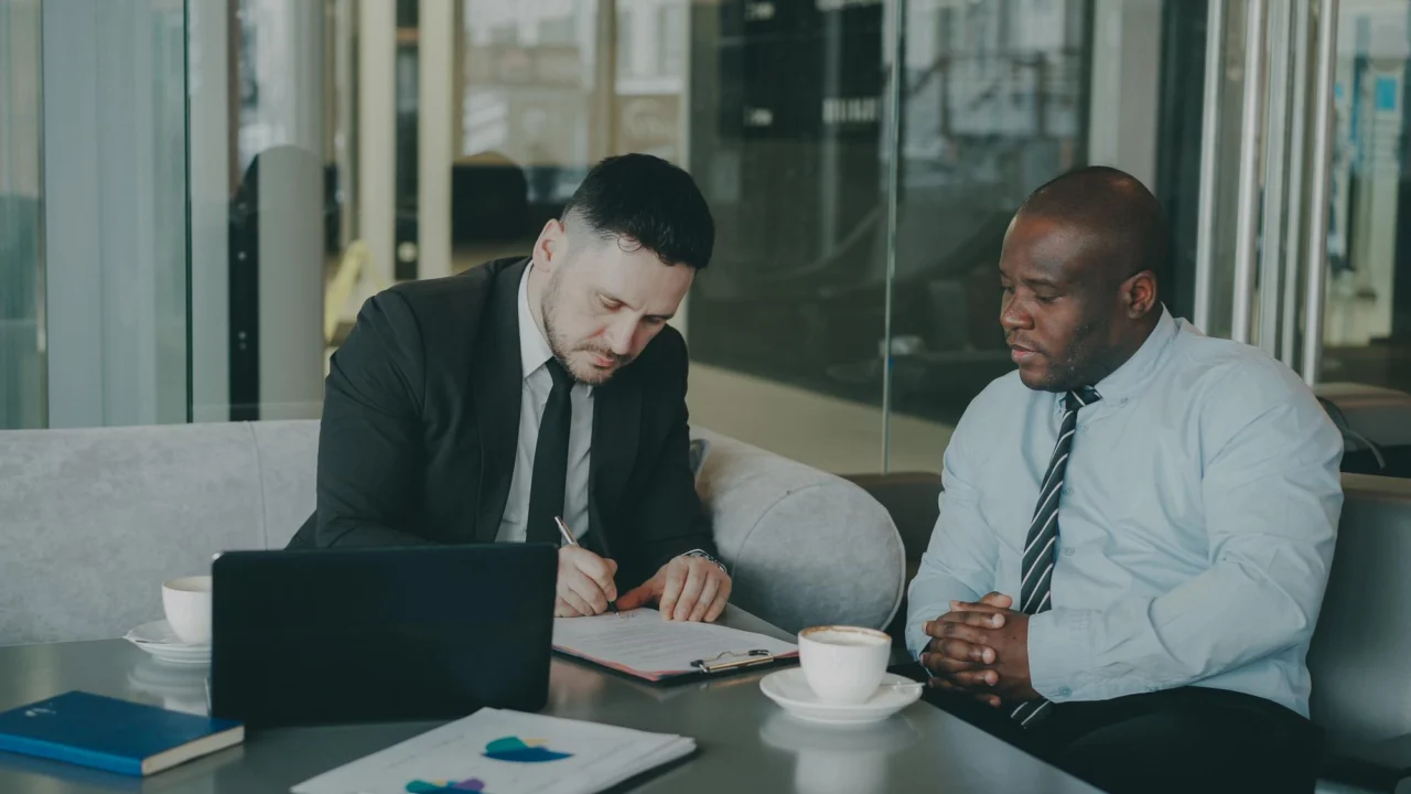 A founder and investor reviewing terms across a table, deciding together