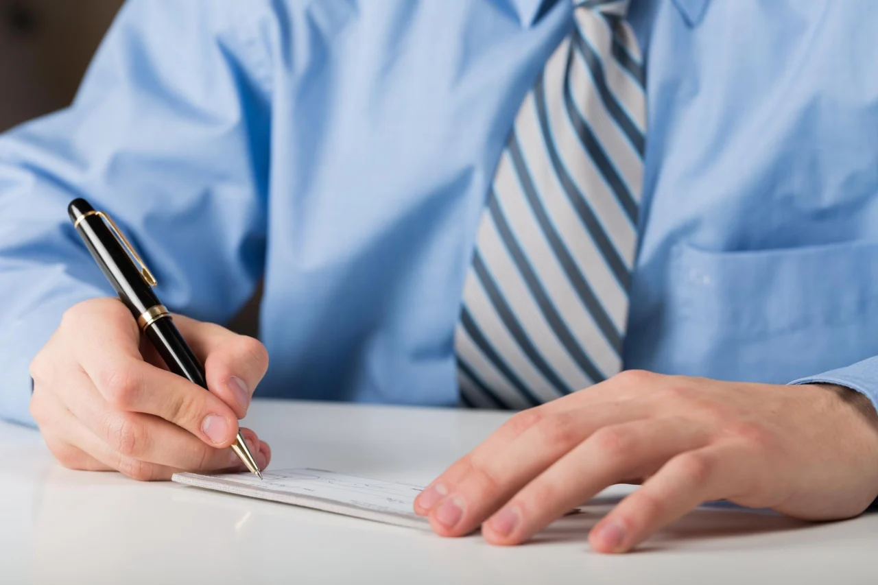 A company director reviewing and signing ownership documents at a desk