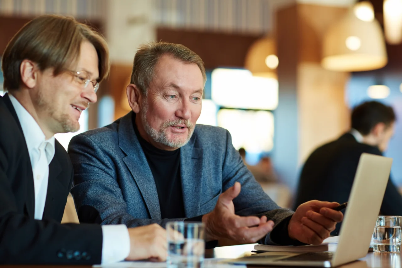 An investor and a founder discussing terms across a laptop