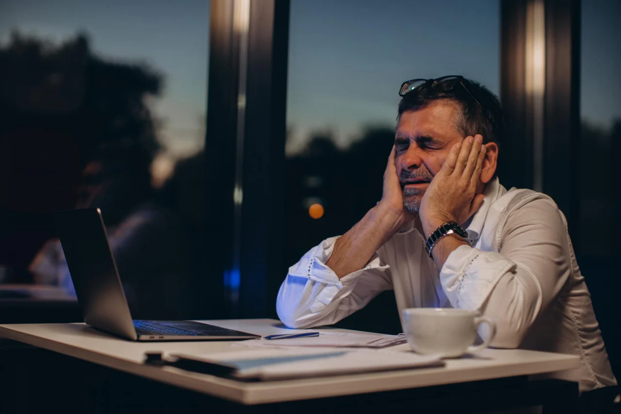 A founder at an overloaded desk as every decision in the business routes back through one person