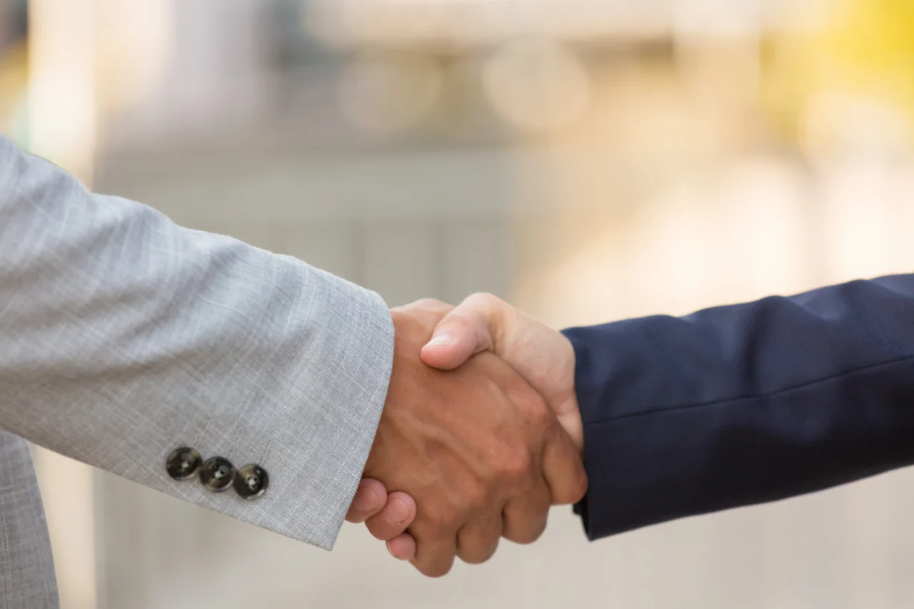 A handshake closing a growth-capital deal between a founder and an investor