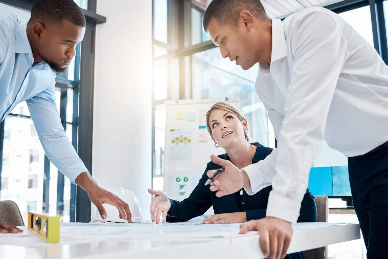 Diverse business team collaborating on plans and documents at an office table