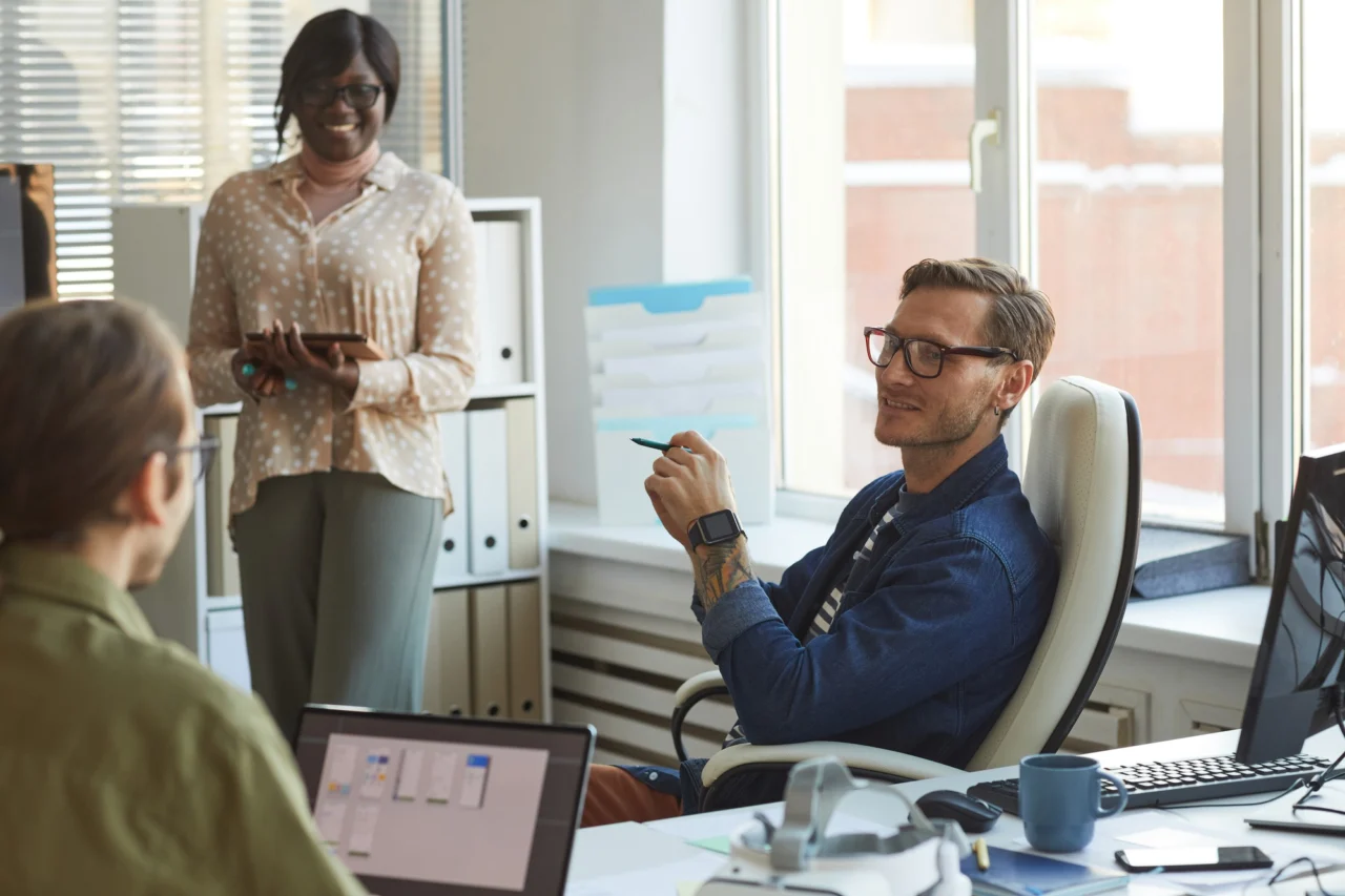 Businessman with a tattoo leading a meeting with colleagues in an office