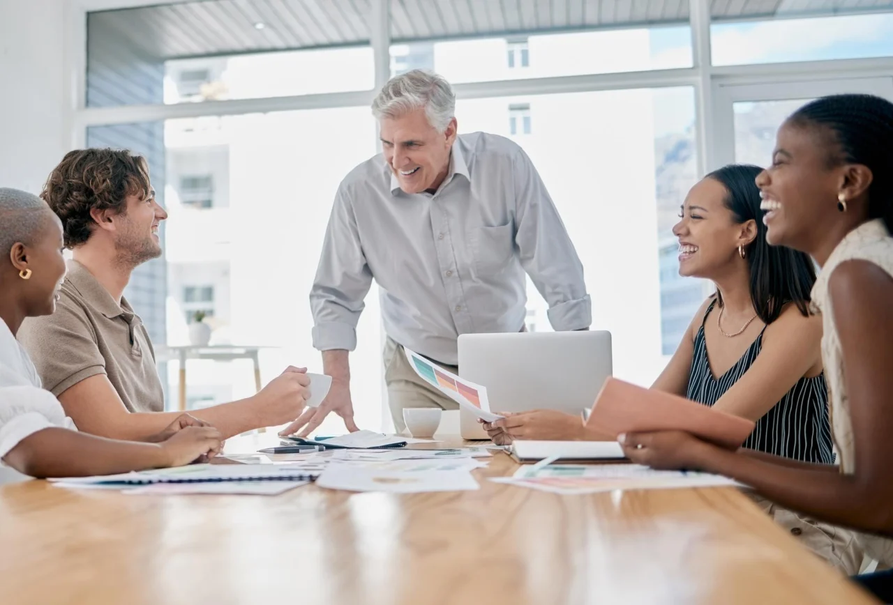 Senior manager leading a brainstorming session with a small team around an office table